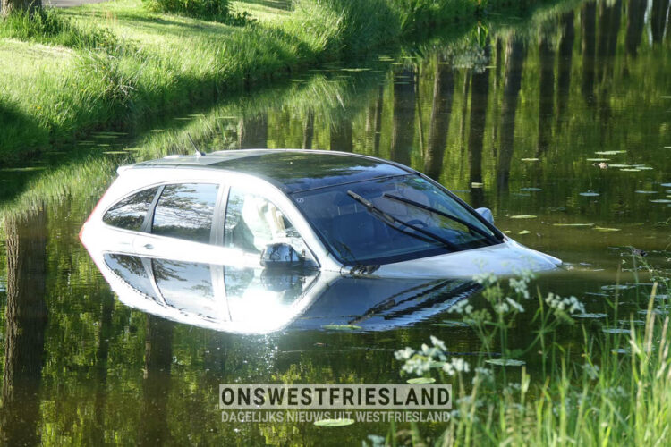 Auto belandt in het water naast Dijkgraaf Grootweg in Andijk