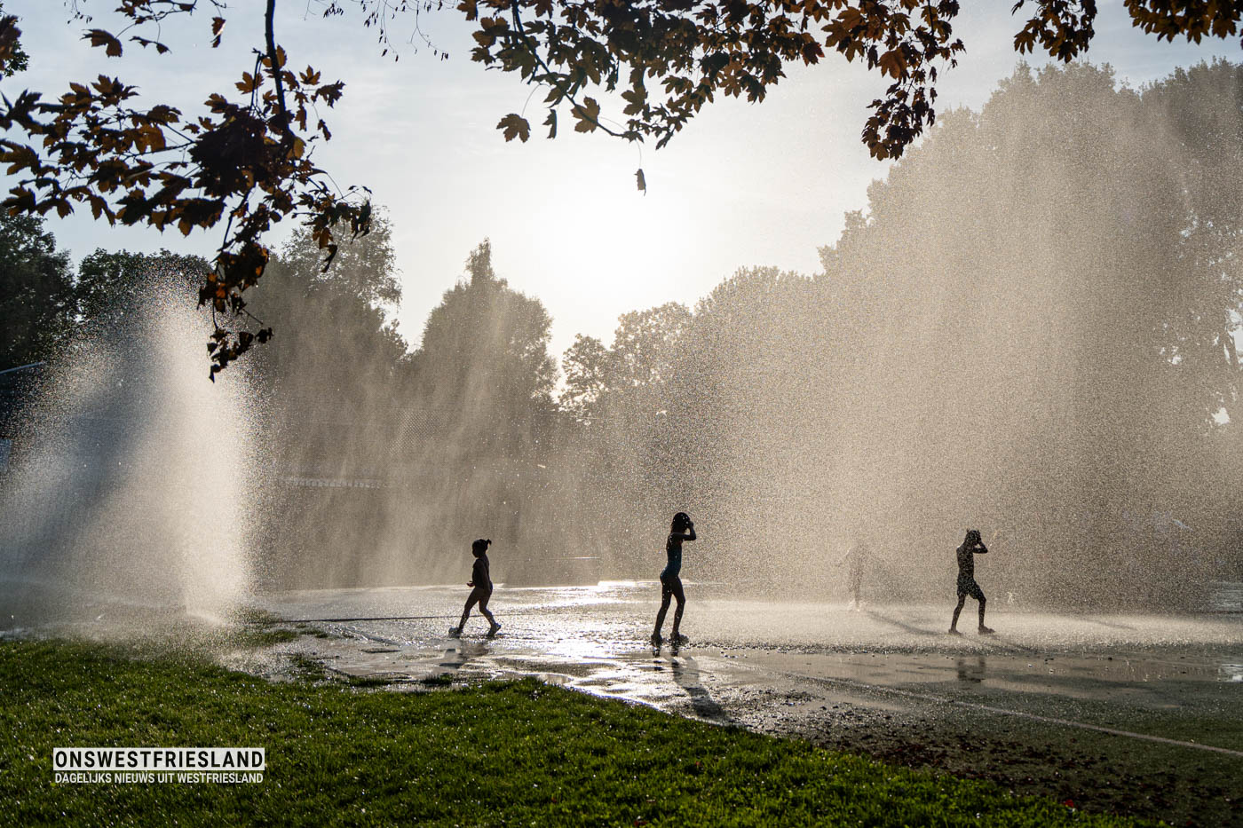 Kinderen zoeken en vinden verkoeling tijdens waterpret in Risdam Zuid (foto’s)