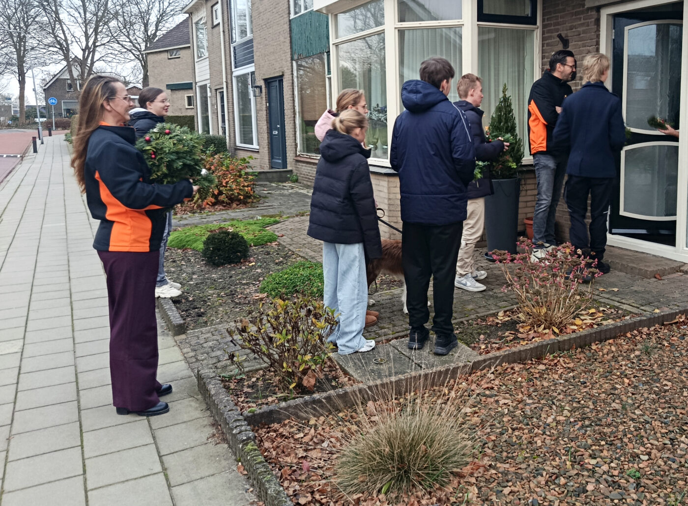 Leerlingen Vonk Grootebroek delen kerstkransen en kerstgevoel uit in de buurt